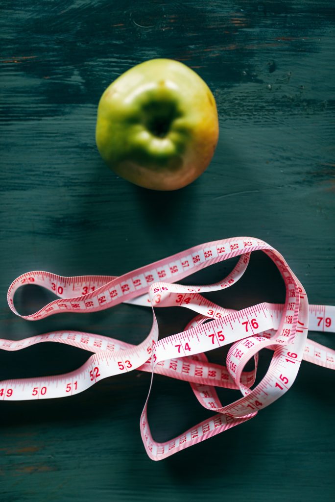 Apple and pink measuring tape, weight loss concept