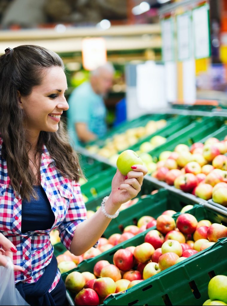 Couple shopping for veggies and fruit in supermarket