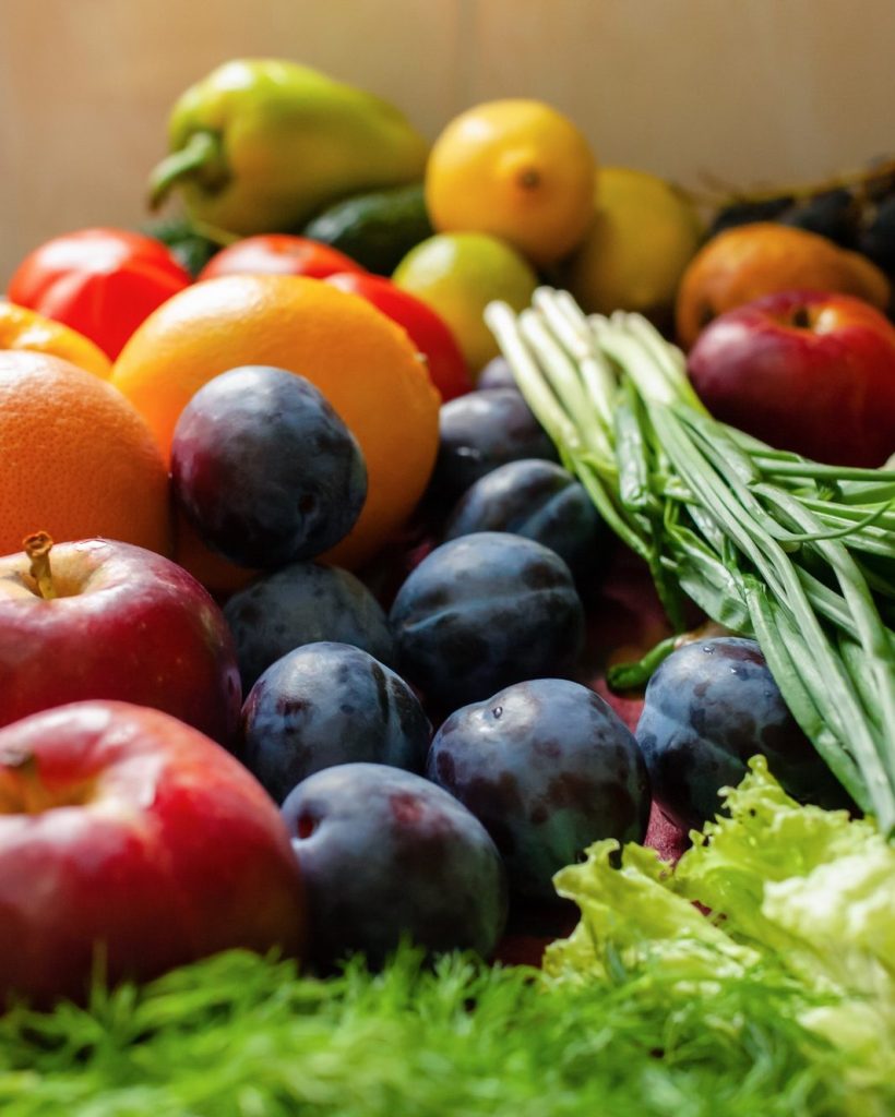 Fruits, vegetables and greens lie on the table, natural light