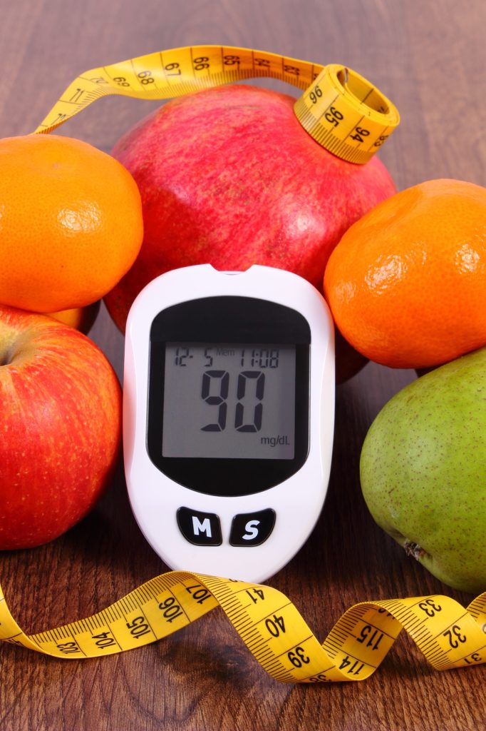 Glucometer with centimeter and fresh fruits, concept of diabetes and healthy nutrition